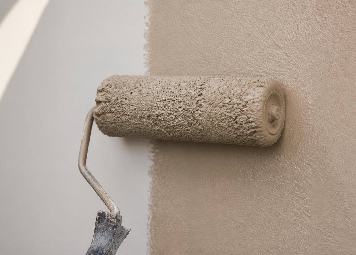 Paint roller applying a fresh even coat to an interior wall
